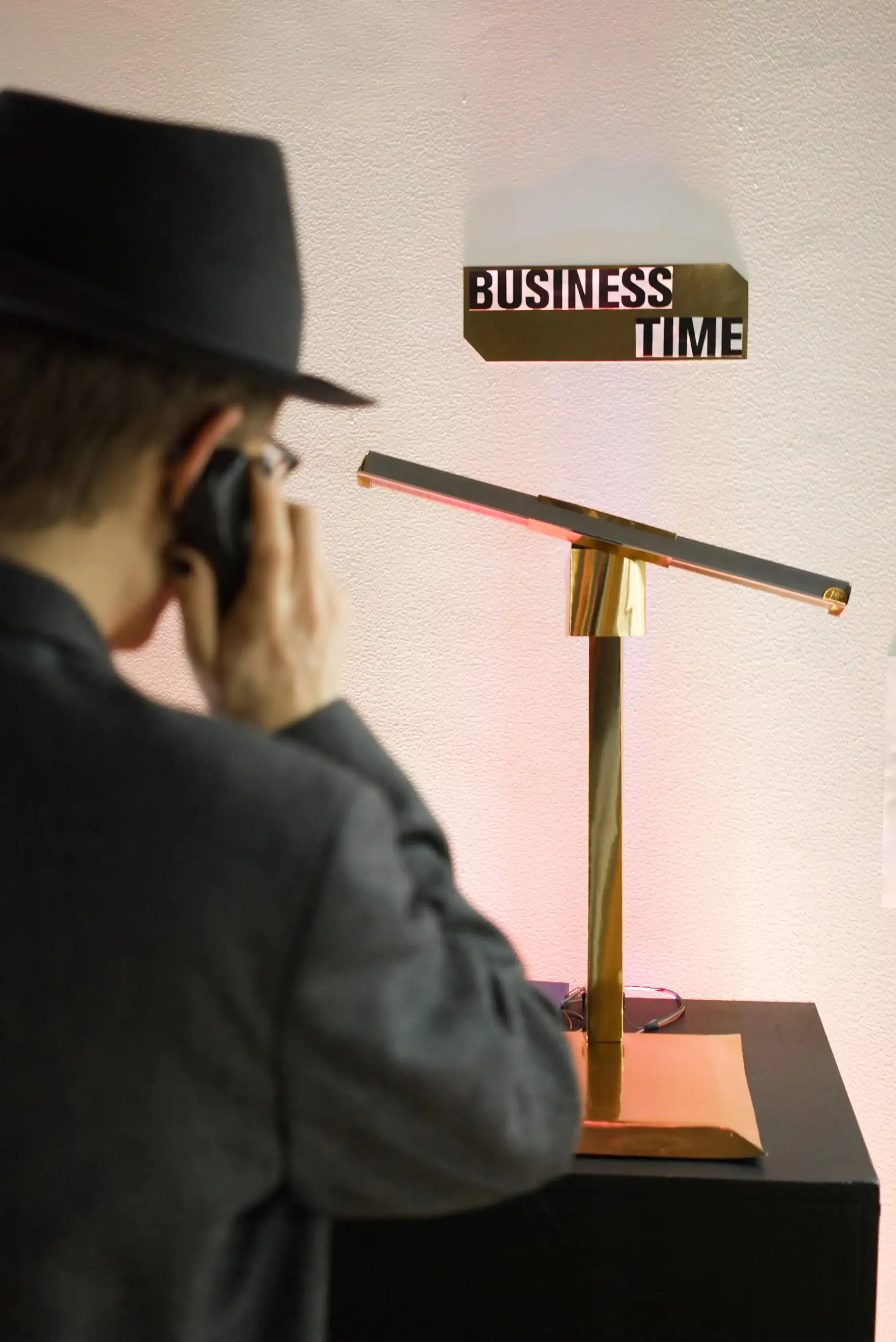 A person dressed in formal clothes speaking on the phone looking at a scales.