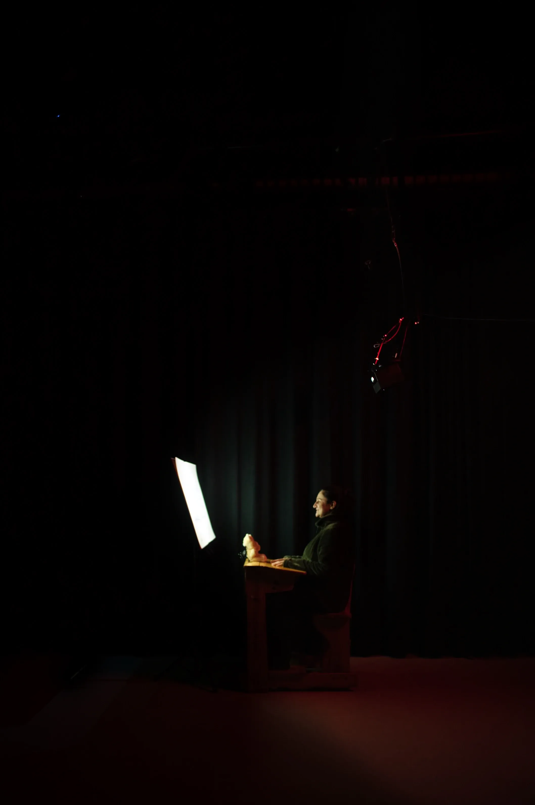 Wide shot, a person sitting at a school desk staring at a book.